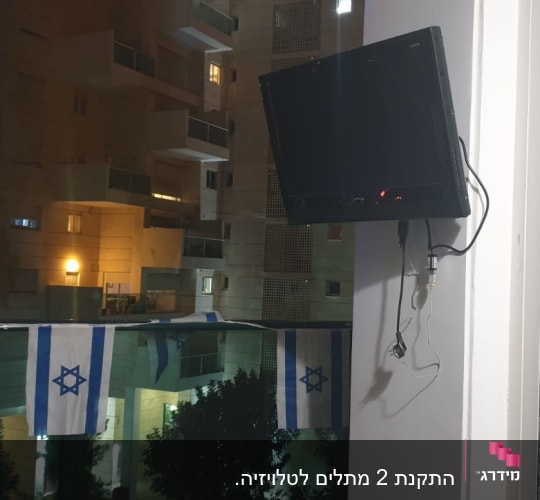 מסך טלוויזיה תלוי על הקיר עם כבלים חשמליים